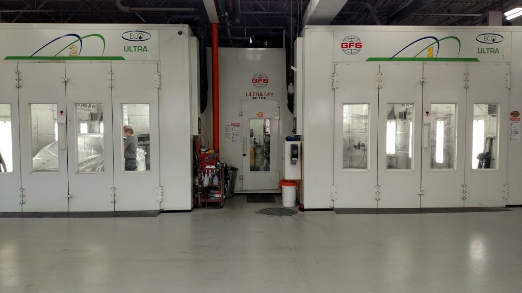 A heated downdraft water spray paint booth