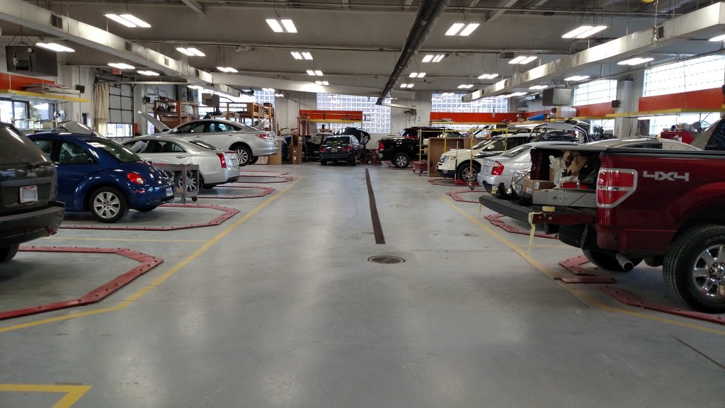 Vehicles being repaired inside the Harden Auto Body shop floor